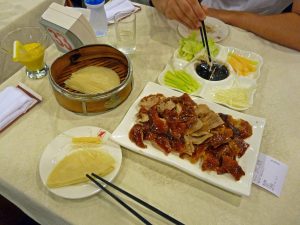 Pekingente mit Teigscheiben und Salat