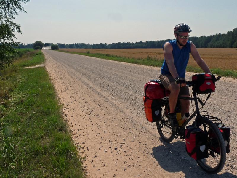 Radfahrer mit Gepäck auf einer Schotterstraße in Lettland